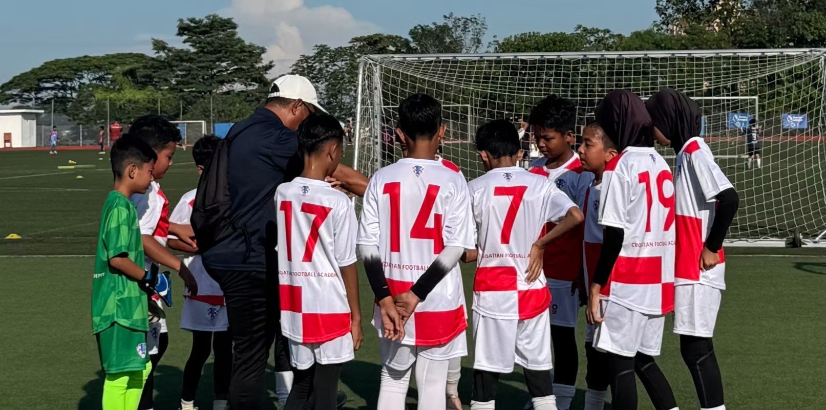 CFA Malaysia coach with players in a team huddle
